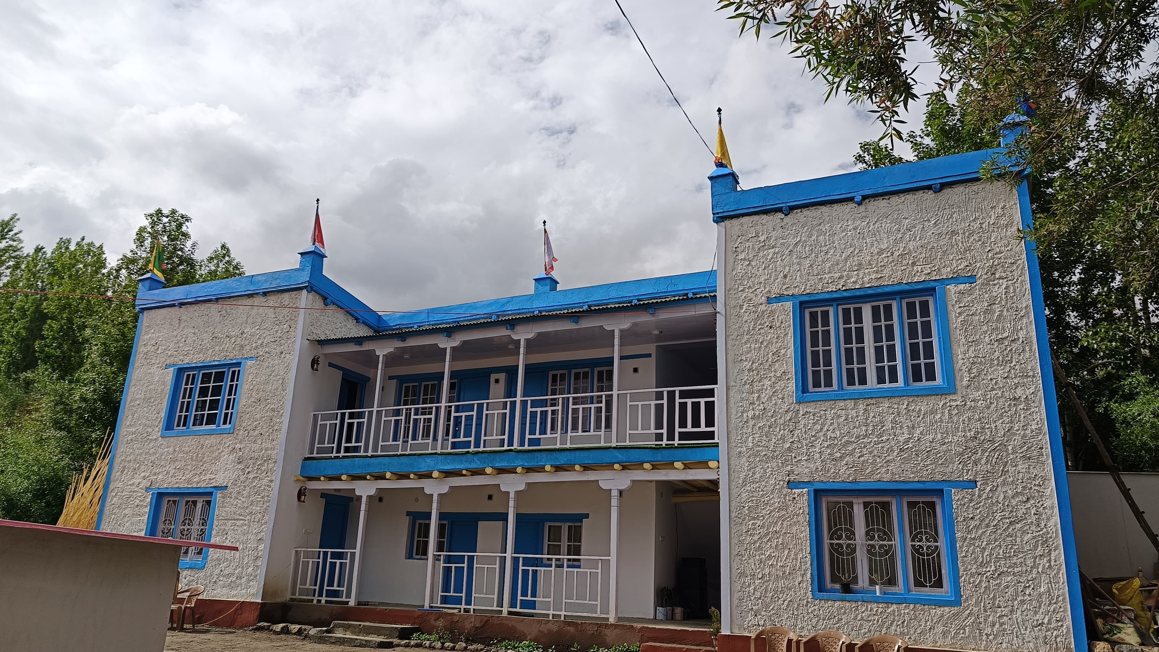 House Of Karma hostel building in Leh, Ladakh with traditional whitewashed walls and azure blue balconies
