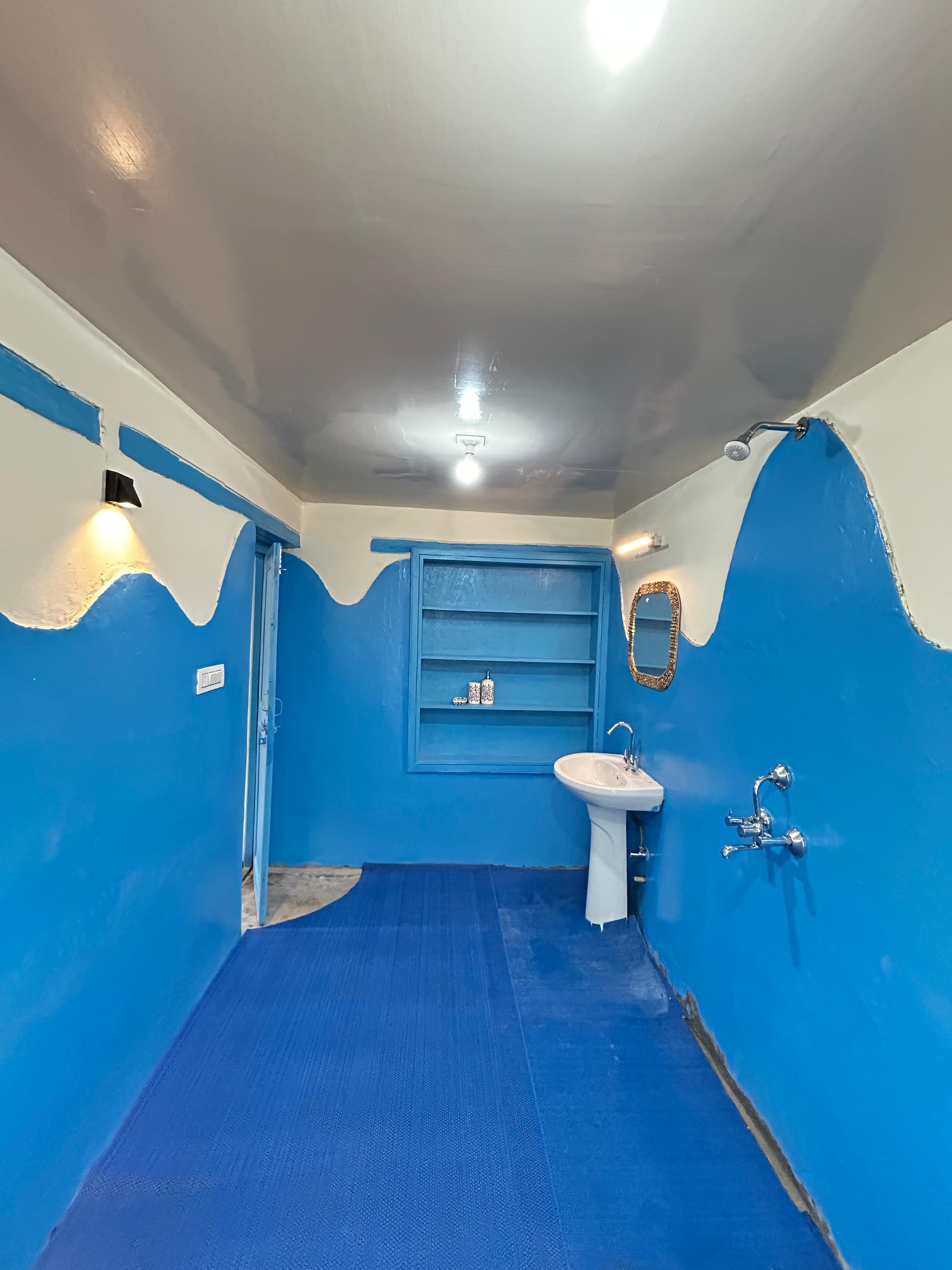 Artistic flowing blue and white mountain wave wall mural inside House Of Karma ensuite bathroom